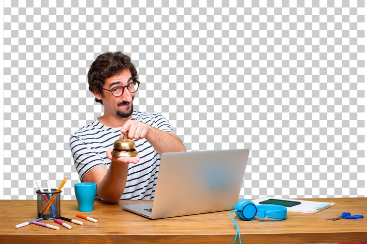 PSD young crazy graphic designer on a desk with a laptop and with a ring bell