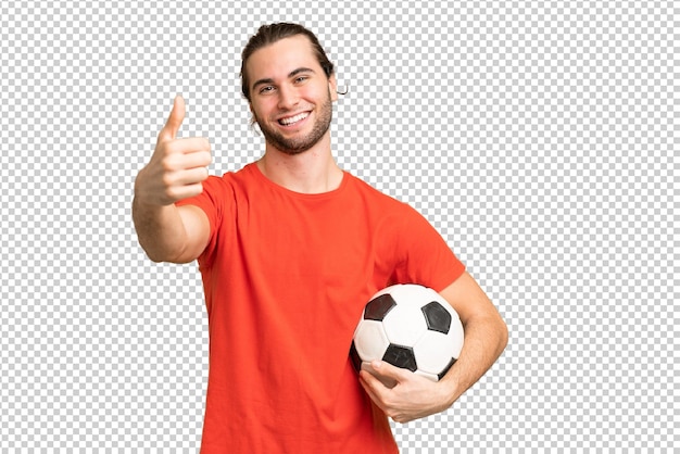Young handsome man isolated on green chroma background with soccer ball and with thumb up