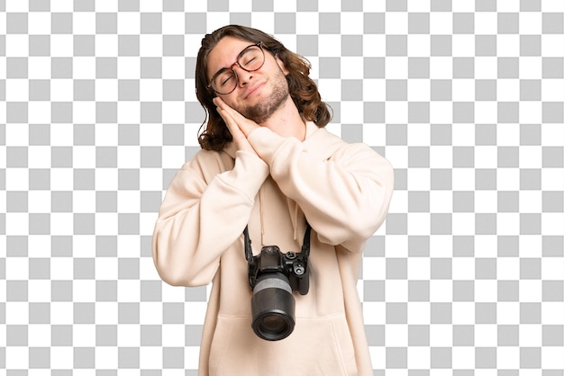 Young photographer man over isolated background making sleep gesture in dorable expression