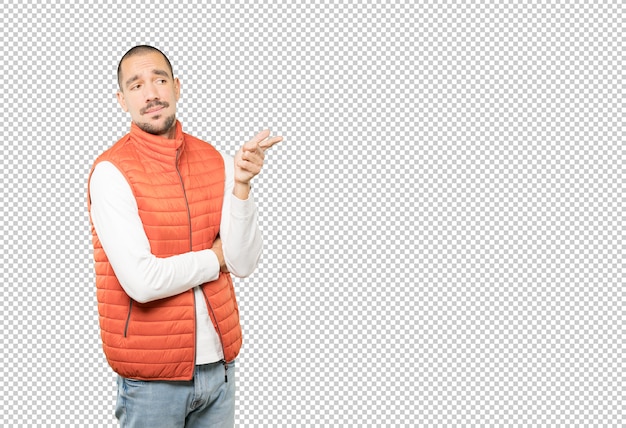Zögernder junger Mann, der mit seinem Finger auf dich zeigt
