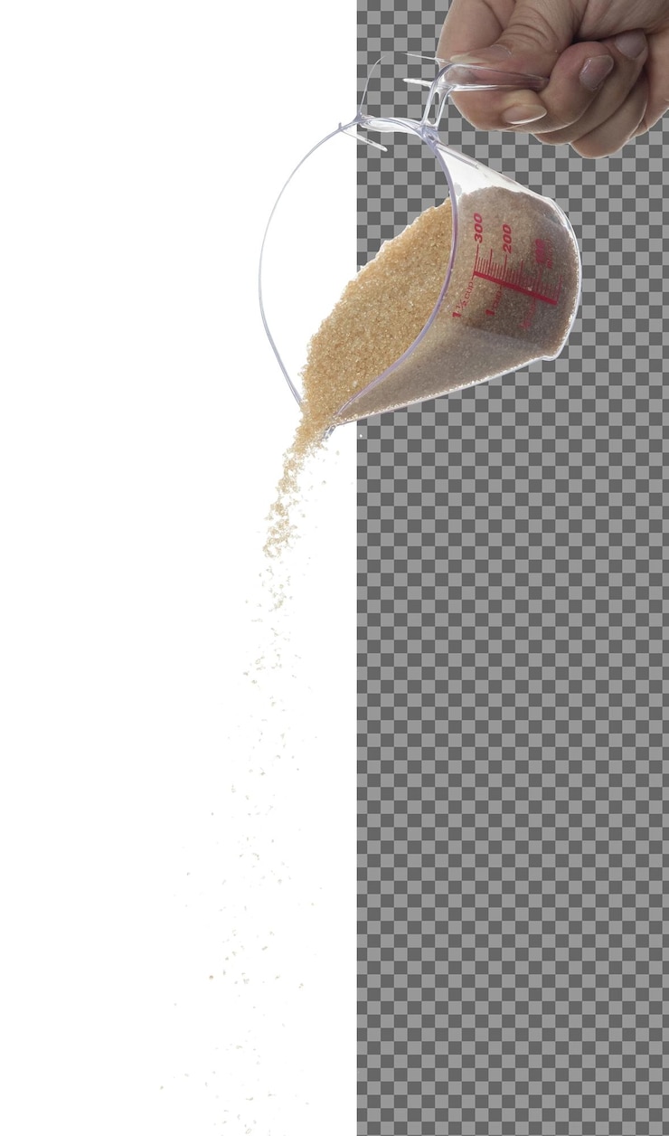 PSD zucchero marrone cadere zucchero di grano marrone versare giù nube astratta volare dalla tazza di misurazione bellissimo seme completo canna da zucchero cibo oggetto di progettazione selettiva messa a fuoco congelamento colpo sfondo bianco isolato