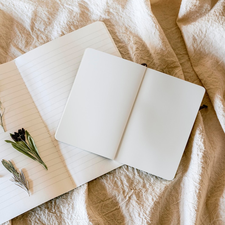 PSD zwei offene notebook-psd-mockup und blumen auf einer leinendecke