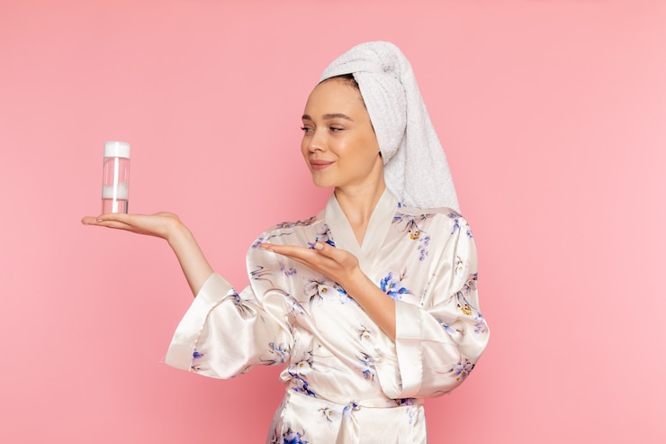 Ücretsiz Fotoğraf a front view young beautiful lady in bathrobe holding make-up cleaner spray