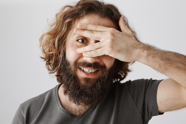 Ücretsiz Fotoğraf close-up of excited bearded middle-eastern man peeking through fingers curious