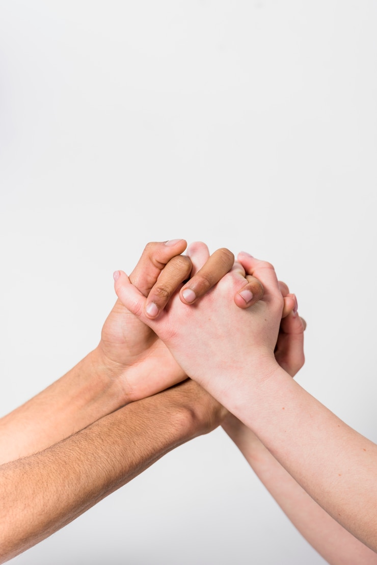 Ücretsiz Fotoğraf close-up of interracial couple holding each other's hand against white background