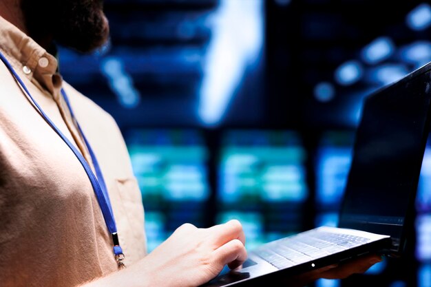Close up shot of technician inspecting crypto mining server rigs solving complex mathematical equations Specialist using laptop in data center housing blockchain technology high volume transactions