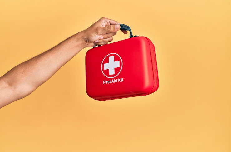 Ücretsiz Fotoğraf hand of hispanic man holding first aid kit over isolated yellow background.