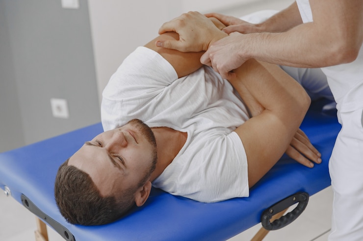 Ücretsiz Fotoğraf man in the medical office. physiotherapist is rehabilitating back.