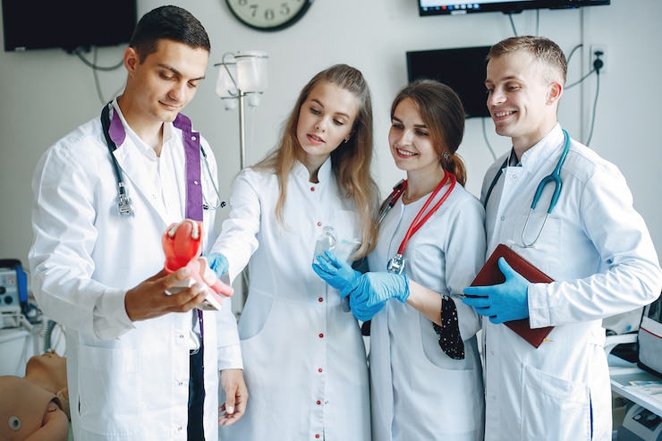 Ücretsiz Fotoğraf men and women in hospital gowns hold medical equipment in their hands