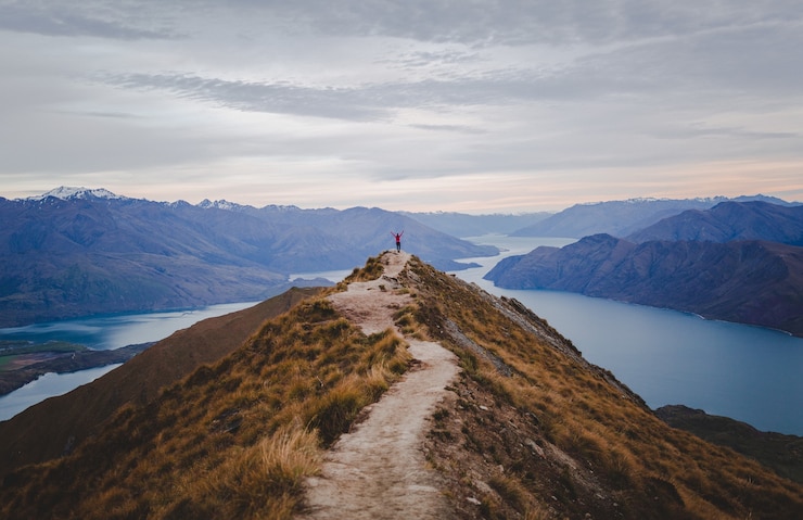 Ücretsiz Fotoğraf panoramic view of the roys peak in new zealand with low mountains in the distance under cloudscape