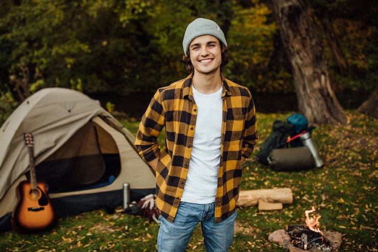 Ücretsiz Fotoğraf portrait of young male tourist standing in the forest with tent