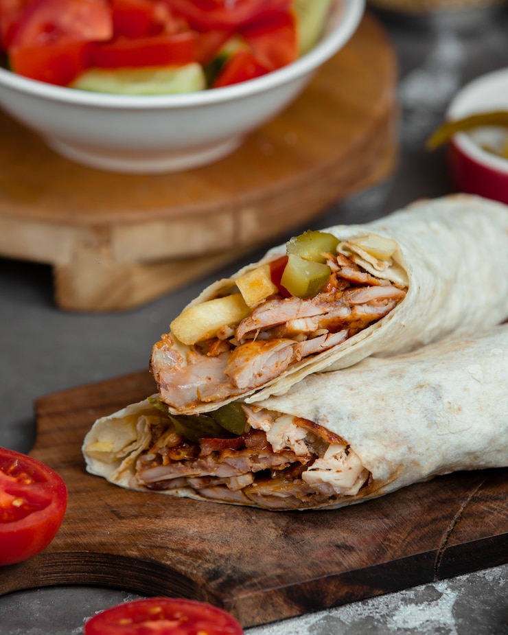 Ücretsiz Fotoğraf sandwich in lavash on a wooden platter.