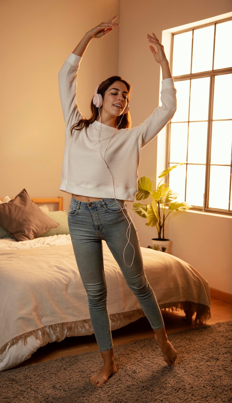 Ücretsiz Fotoğraf woman using headphones for music at home and dancing