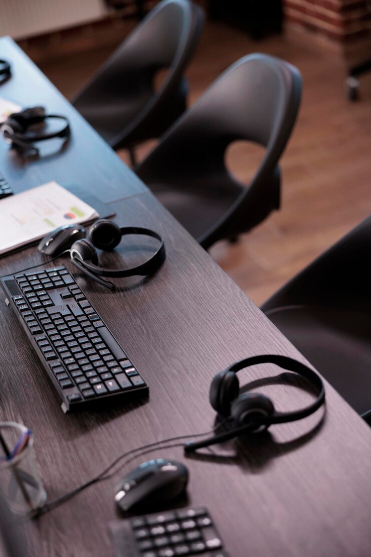 Ücretsiz Fotoğraf yardım sağlamak için resepsiyonda telefon ekipmanlarının bulunduğu boş yardım masası ofisi. müşteri hizmetleri ve müşteri desteği için tele pazarlama alanında insan yok, uzaktan yardım hattı kulaklıkları.