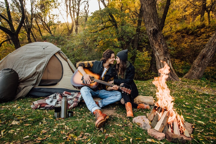 Ücretsiz Fotoğraf young loving couple of tourists relaxing near the fire in the nature