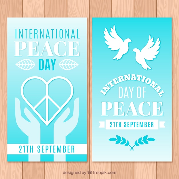 Vecteur gratuit bannières pour le jour de la paix avec le coeur et les colombes