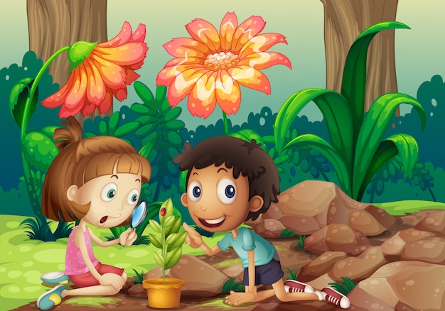 Une fille et un garçon regardant la plante à la loupe