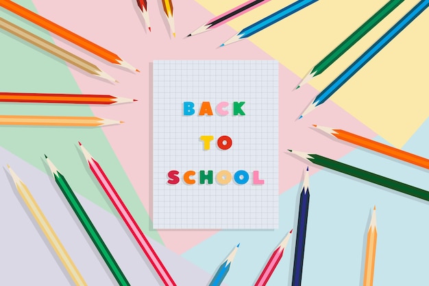 Retour à l'école cahier d'école et crayons sur fond multicolore concept de l'éducation