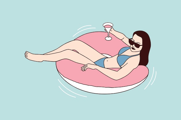 Belle Femme Profiter De L'été Sur Un Flotteur De Piscine à Anneau Gonflable Avec Un Cocktail