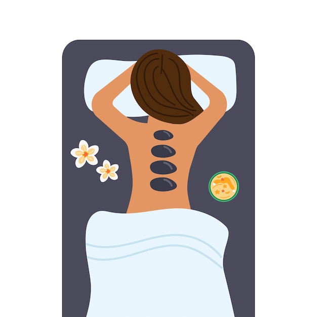 Concept de massage à la pierre chaude femme allongée sur le ventre avec des pierres chaudes sur le dos