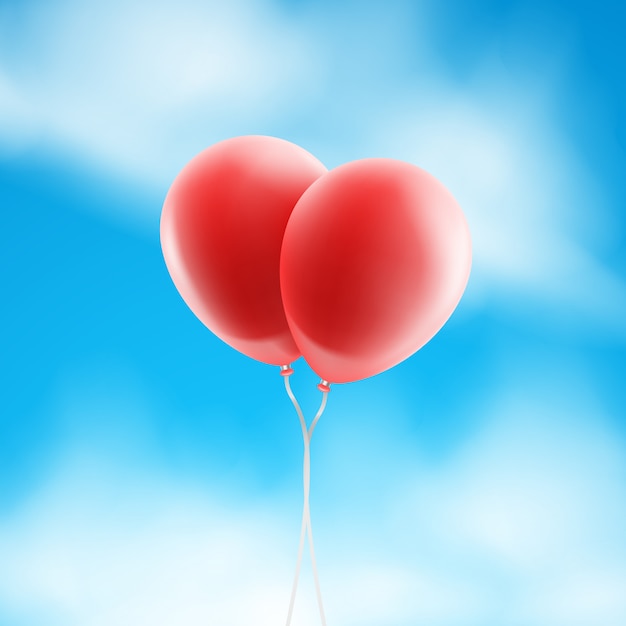 Deux ballons rouges en forme de coeur sur le fond de ciel.