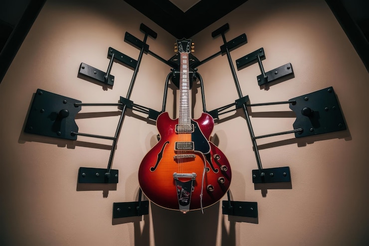 Vecteur une guitare électrique rouge accrochée à un mur avec d'autres haut-parleurs