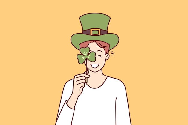 Homme Avec Des Accessoires De Célébration De La Saint-patrick Portant Un Chapeau Vert Et Couvrant Les Yeux Avec Un Pétale De Trèfle