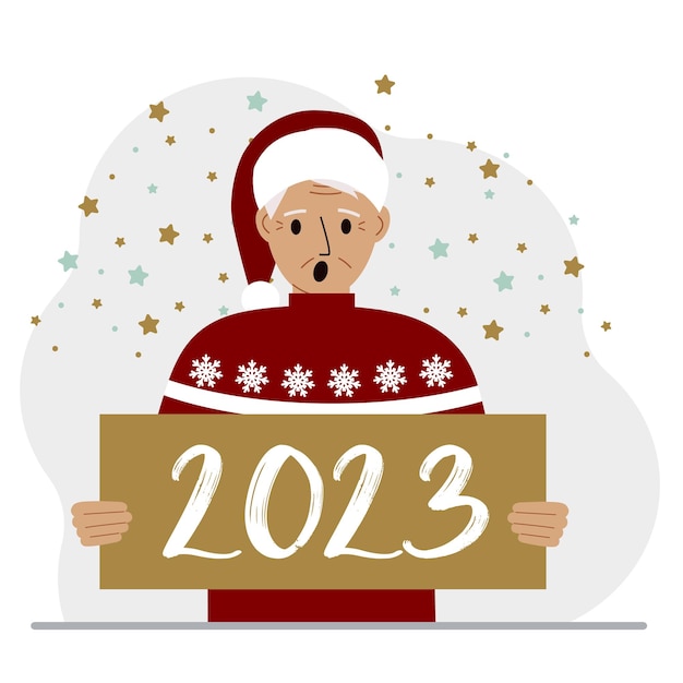 Un homme en pull rouge et avec une casquette tient une pancarte ou une affiche avec les numéros 2023 Carte postale ou salutation Joyeux Noël et bonne année
