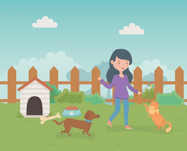 Jeune femme avec d'adorables petits mascottes chien et chat sur le terrain