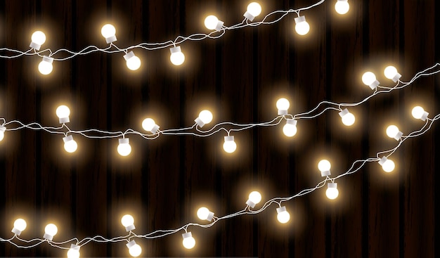 Lumières de Noël isolées sur fond de bois foncé Guirlande lumineuse Vecteur lueur ampoules de Noël sur les fils