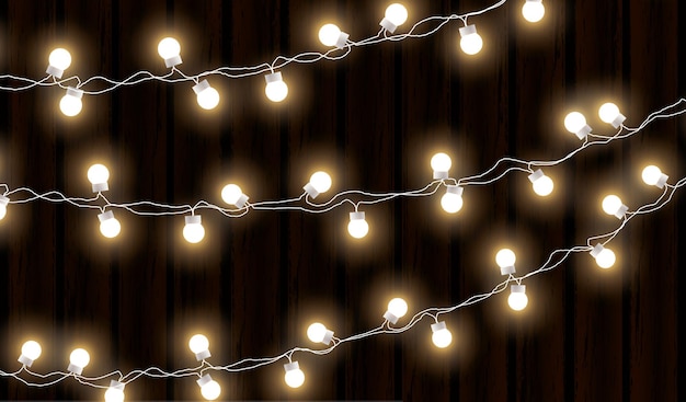 Vecteur lumières de noël isolées sur fond de bois foncé guirlande lumineuse vecteur lueur ampoules de noël sur les fils