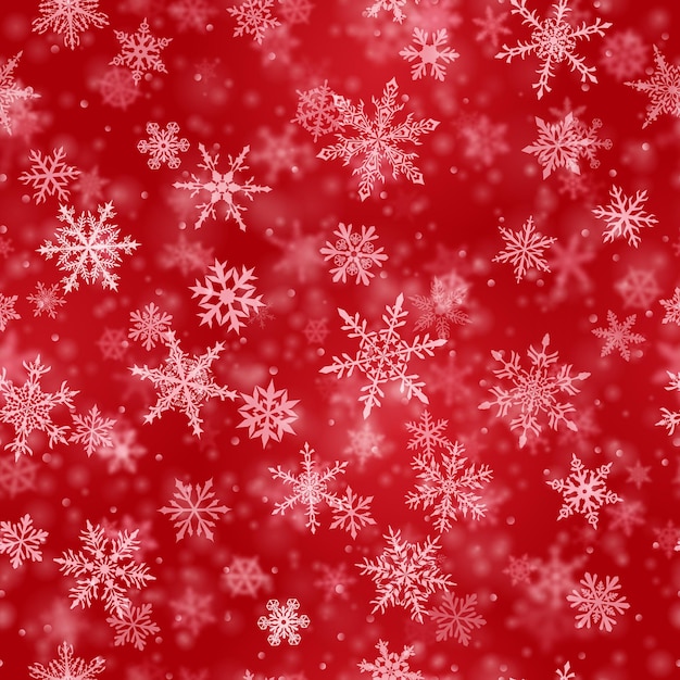 Modèle sans couture de Noël de flocons de neige tombant flous et clairs complexes dans des couleurs rouges avec effet bokeh