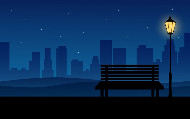 Nuit en ville avec banc dans un parc public