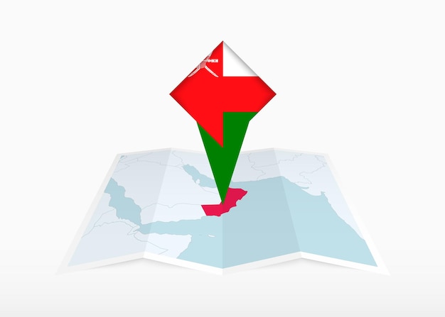 Oman est représenté sur une carte en papier pliée et un marqueur d'emplacement épinglé avec le drapeau d'Oman.