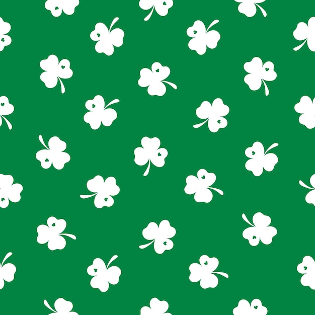 Vecteur un petit trèfle blanc est éparpillé sur un fond vert joyeux jour de saint-patrick motif sans couture