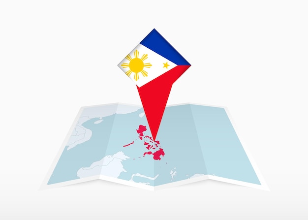 Les Philippines sont représentées sur une carte en papier pliée et un marqueur d'emplacement épinglé avec le drapeau des Philippines.