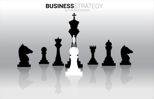 Silhouette d'homme d'affaires debout sur une pièce d'échecs pion blanc devant toute la pièce d'échecs noire.
