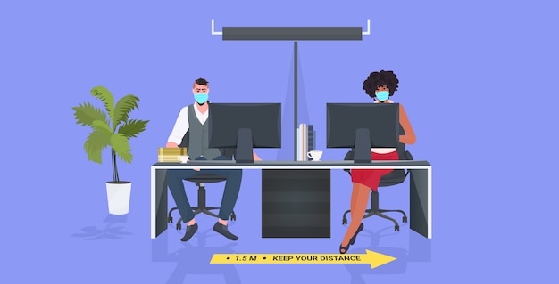businesspeople in masks sitting at workplace keeping distance to prevent coronavirus epidemic