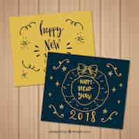 Vector gratuito conjunto de dos tarjetas de felicitación de año nuevo dibujadas a mano