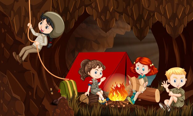 Escena con niños felices acampando en la cueva en la noche