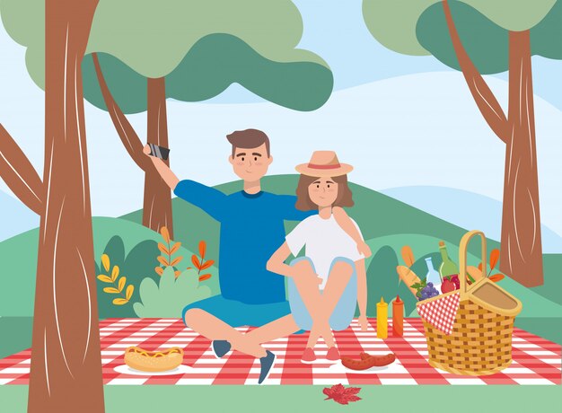 Hombre y mujer en mantel con cesta y comida.
