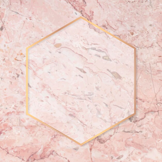 Marco dorado hexagonal sobre fondo de mármol rosa