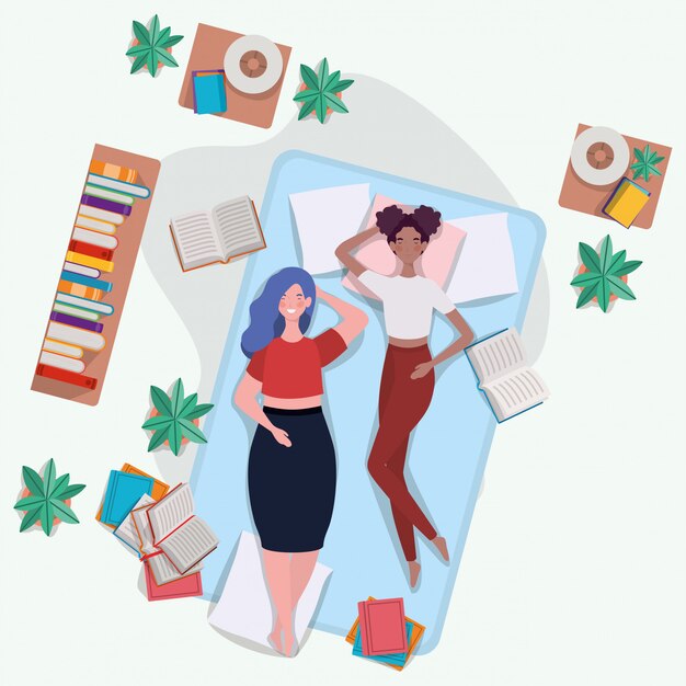 Mujeres interraciales descansando en un colchón en el dormitorio.
