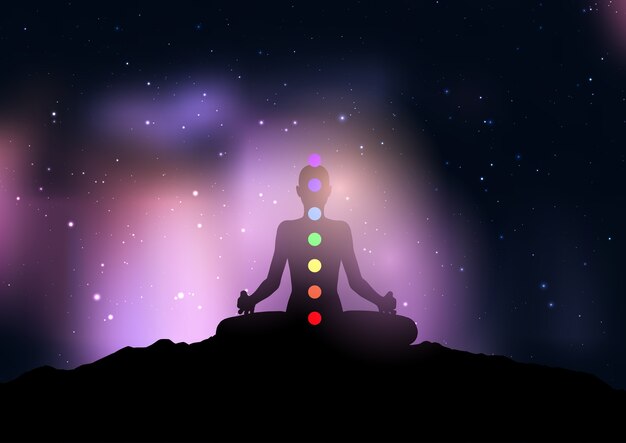 Silueta de una mujer con chakra en pose de yoga contra el cielo nocturno estrellado
