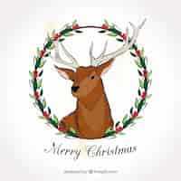 Vector gratuito tarjeta de feliz navidad de ciervo dibujado a mano con corona floral