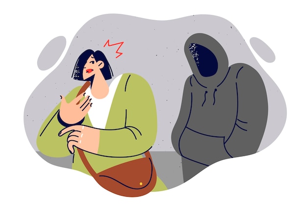 El acosador acecha a la mujer escondiendo la cara bajo el capó para cometer un crimen y robar el bolso.