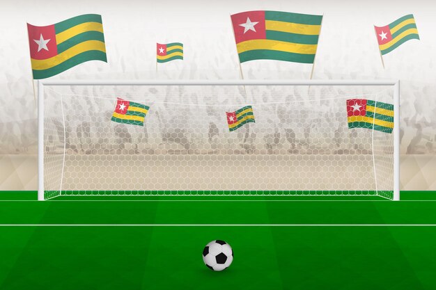 Aficionados del equipo de fútbol de Togo con banderas de Togo animando el concepto de tiro penal del estadio en un partido de fútbol