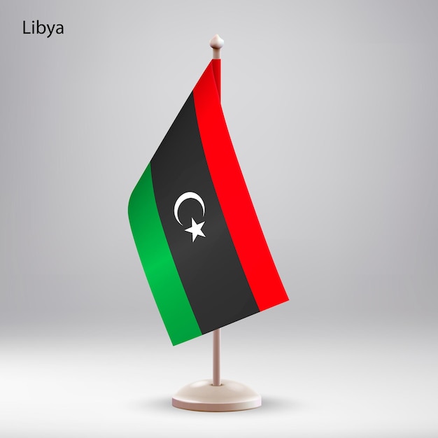 Vector la bandera de libia colgando en un soporte de bandera