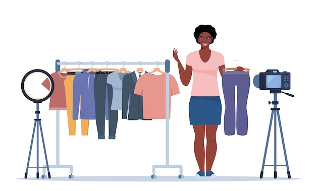 Una bloguera negra graba consejos de video para elegir ropa y muestra la ropa de moda