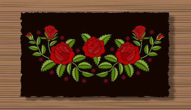 Bordado de flores con ramitas en una tela de solapa oscura y fondo de textura de madera. adorno floral con puntadas rosas